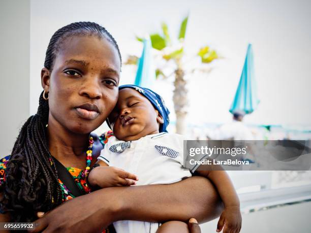 giovane madre emigrante africana con bambino - immigrati foto e immagini stock