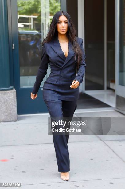 Kim Kardashian wears a blue pinstripe power-suit to attend the Forbes Women's Summit on June 13, 2017 in New York City.