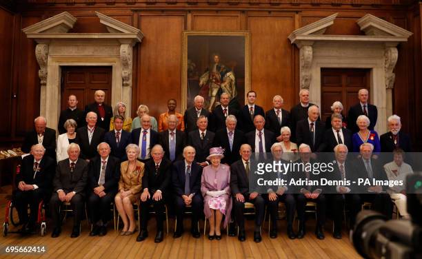 Queen Elizabeth II and the Duke of Edinburgh during a photo with Companions of Honour after a reception in celebration of the centenary of the Order...