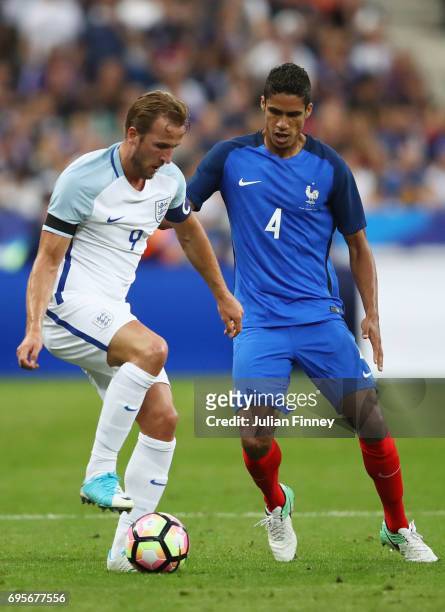 Harry Kane of England holds off Raphael Varane of France during the International Friendly match between France and England at Stade de France on...