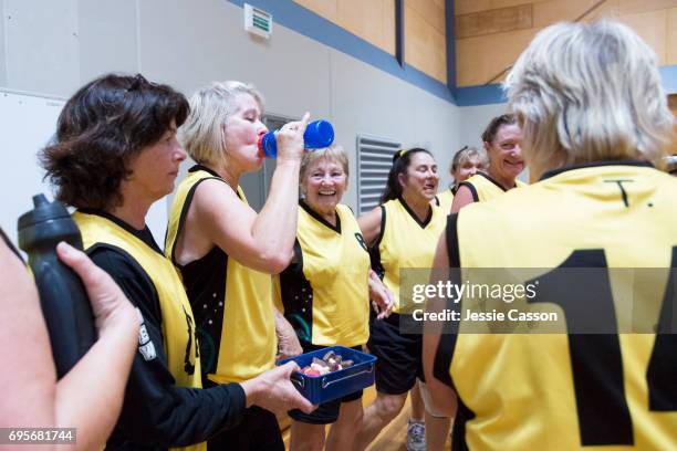 senior female basketball players have team talk on indoor court - food court stock-fotos und bilder