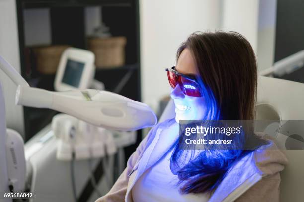 donna che sbianca i denti con il laser - sbiancamento dentale foto e immagini stock