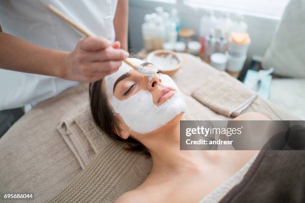 bella donna che si bee un viso al centro benessere - esfoliazione foto e immagini stock