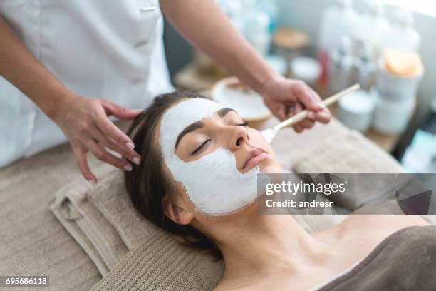 schöne frau, die immer ein facemask im spa - schönheitssalon stock-fotos und bilder