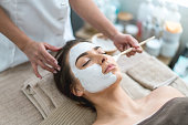Beautiful woman getting a facemask at the spa