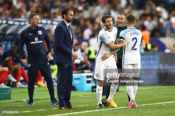 Adam Lallana of England replaces Kieran Trippier of England as a substitute as Gareth Southgate manager of England looks on during the International...