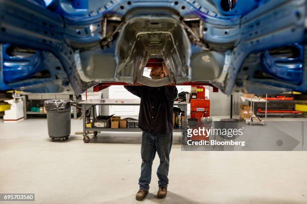 An employee works on the chassis of a General Motors Co. Chevrolet COPO Camaro performance vehicle at the company's build center in Oxford, Michigan,...