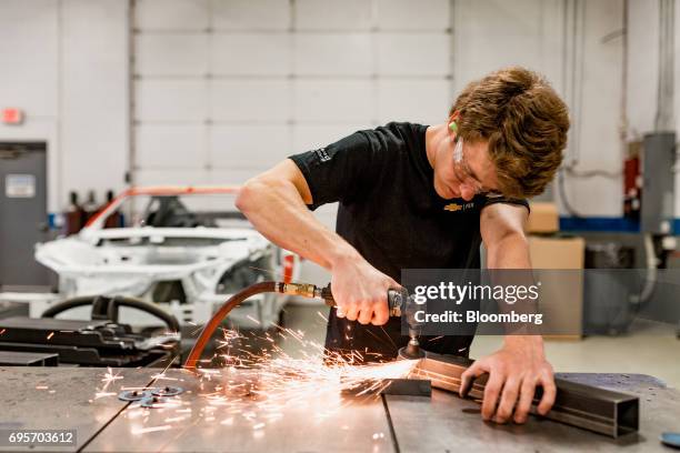 An employee grinds frame rail connectors while working on the chassis of a General Motors Co. Chevrolet COPO Camaro performance vehicle at the...