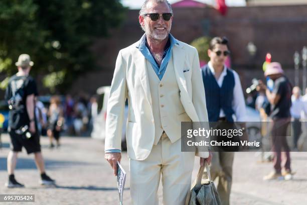 Alessandro Squarzi wearing a creme suit, weekender bag is seen during Pitti Immagine Uomo 92. At Fortezza Da Basso on June 13, 2017 in Florence,...