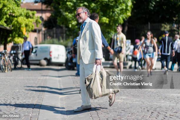 Alessandro Squarzi wearing a creme suit, weekender bag is seen during Pitti Immagine Uomo 92. At Fortezza Da Basso on June 13, 2017 in Florence,...