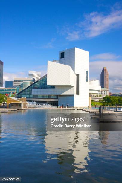 reflection in water of rock and roll hall of fame, cleveland - rock and roll hall of fame cleveland stock pictures, royalty-free photos & images