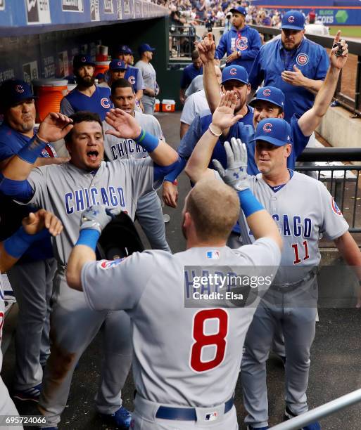 Ian Happ of the Chicago Cubs is congratulated by Kyle Schwarber and the rest of his teammates in the dugout after he hit a grand slam in the second...