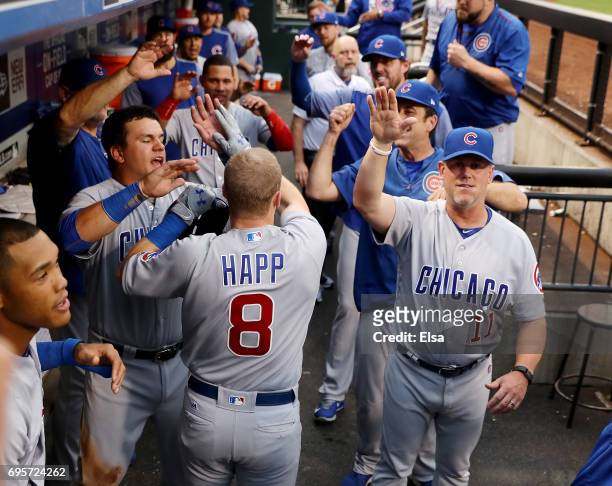 Ian Happ of the Chicago Cubs is congratulated by Kyle Schwarber and the rest of his teammates in the dugout after he hit a grand slam in the second...