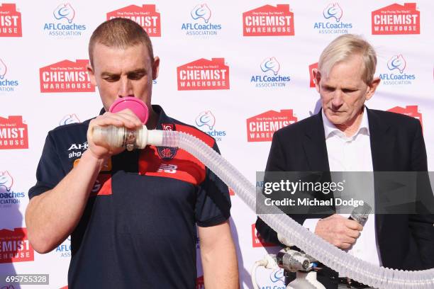 Melbourne Demons head coach Simon Goodwin tests his lung capacity for Men's Health Wellness Week during an AFL media opportunity at the Melbourne...