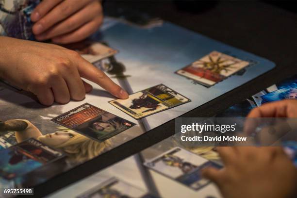 People play the Final Fantasy Trading Card Game at the Square Enix exhibit on opening day of the Electronic Entertainment Expo at the Los Angeles...