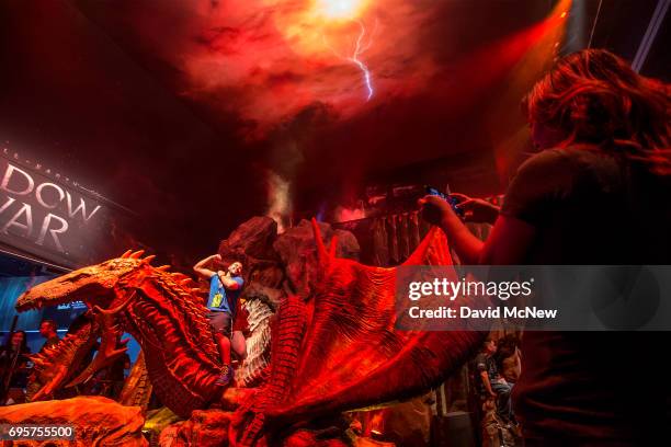 Man gets his a photo taken on a dragon from Middle-earth: Shadow of War from WB Games on opening day of the Electronic Entertainment Expo at the Los...