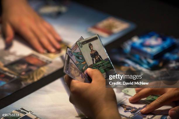 People play the Final Fantasy Trading Card Game at the Square Enix exhibit on opening day of the Electronic Entertainment Expo at the Los Angeles...