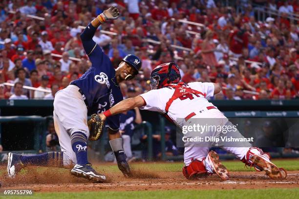 Keon Broxton of the Milwaukee Brewers scores a run against Eric Fryer of the St. Louis Cardinals in the fourth inning at Busch Stadium on June 13,...