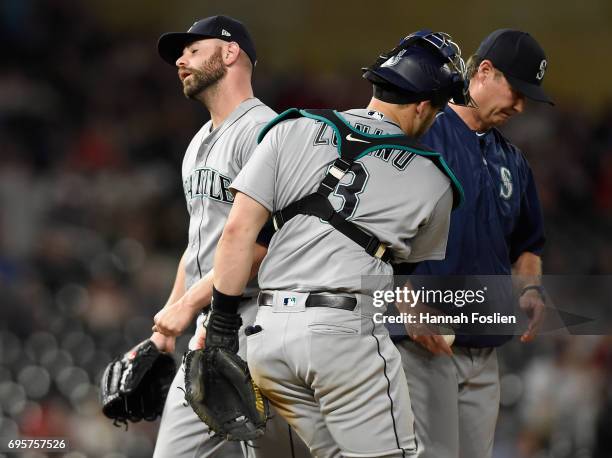 Marc Rzepczynski of the Seattle Mariners leaves the mound during the seventh inning as Mike Zunino and manager Scott Servais look on during the...