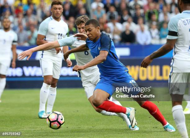 Kylian Mbappe of France and John Stones of England during the international friendly match between France and England at Stade de France on June 13,...