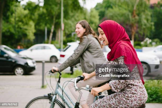 freundschaft: junge muslimin mit hijab und freund fahrrad - islam stock-fotos und bilder
