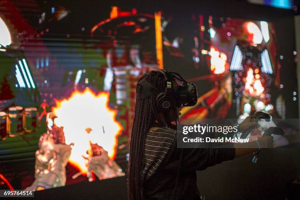 Woman games in virtual reality at the Raw Data exhibit on opening day of the Electronic Entertainment Expo at the Los Angeles Convention Center on...