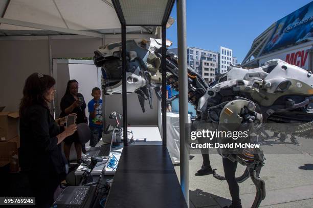 Horizon Zero Dawn machine character investigates a woman in an expo badge pickup booth on opening day of the Electronic Entertainment Expo at the Los...