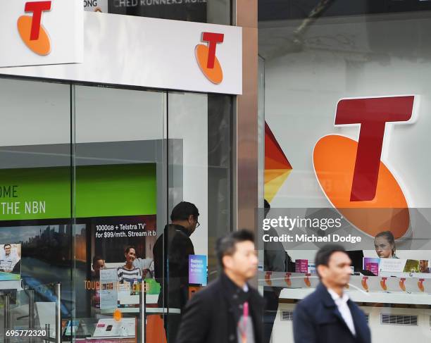 Telstra logo is seen as pedestrian walk outside the Telstra Melbourne headquarters on June 14, 2017 in Melbourne, Australia. Telecommunications...