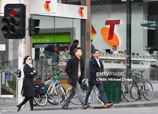 Telstra logo is seen as pedestrians walk outside the Telstra Melbourne headquarters on June 14, 2017 in Melbourne, Australia. Telecommunications...