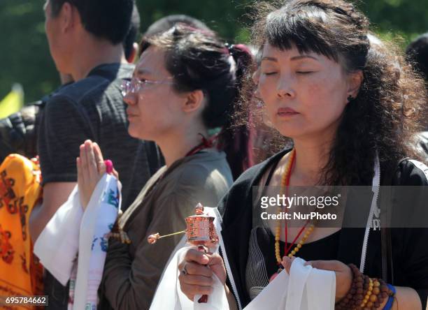 Buddhist woman turns a small prayer wheel as she meditates waiting for the arrival of His Holiness the 17th Gyalwang Karmapa Ogyen Trinley Dorje. The...