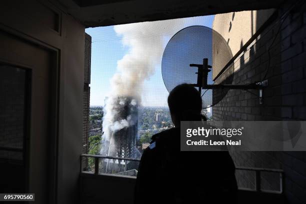 Man watches as smoke continues to rise from the building after a huge fire engulfed the 24 storey residential Grenfell Tower block in Latimer Road,...