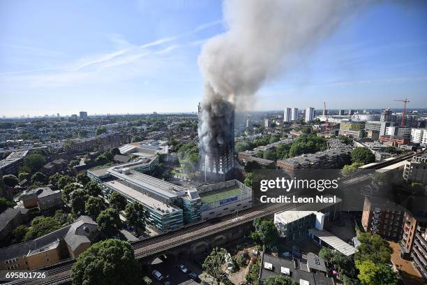 Smoke rises from the building after a huge fire engulfed the 24 storey residential Grenfell Tower block in Latimer Road, West London in the early...
