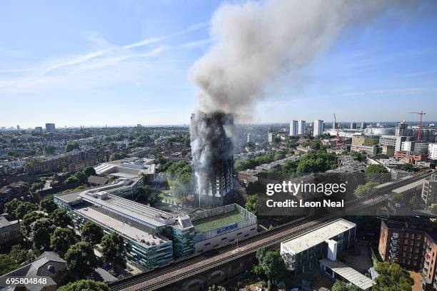 Smoke rises from the building after a huge fire engulfed the 24 storey residential Grenfell Tower block in Latimer Road, West London in the early...