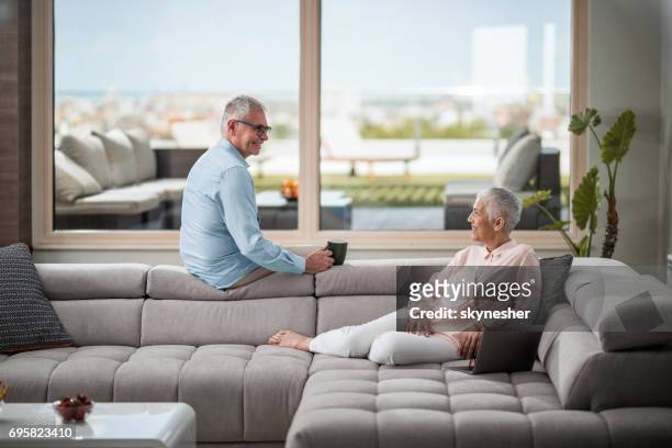 gerne älteres paar in den komfort von ihrem wohnzimmer miteinander zu reden. - penthouse stock-fotos und bilder