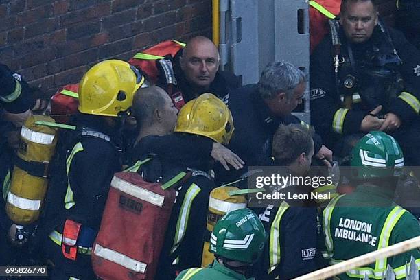 Man is rescued by fire fighters after a huge fire engulfed the 24 storey residential Grenfell Tower block in Latimer Road, West London in the early...