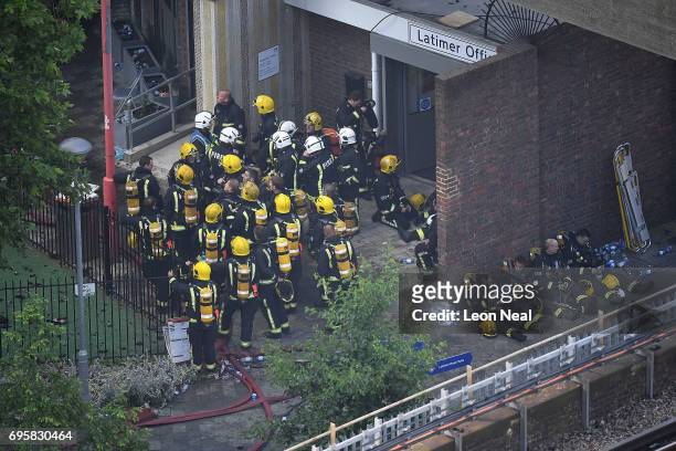 Fire fighters gather near the burning 24 storey residential Grenfell Tower block in Latimer Road, West London on June 14, 2017 in London, England....