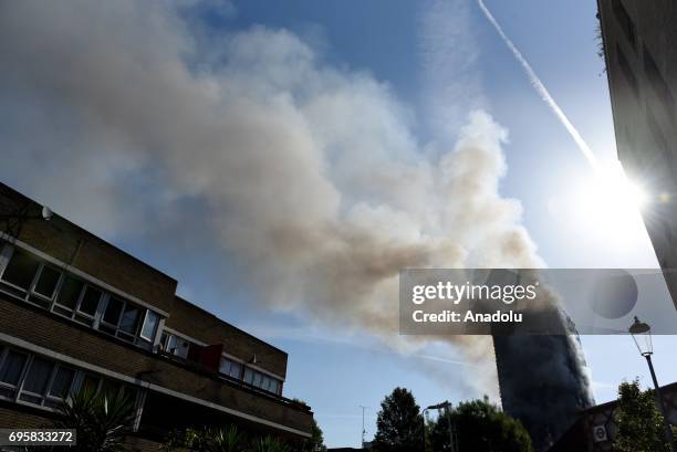 Smoke rises from the building after a huge fire engulfed the 24 storey residential Grenfell Tower block in Latimer Road, West London in the early...