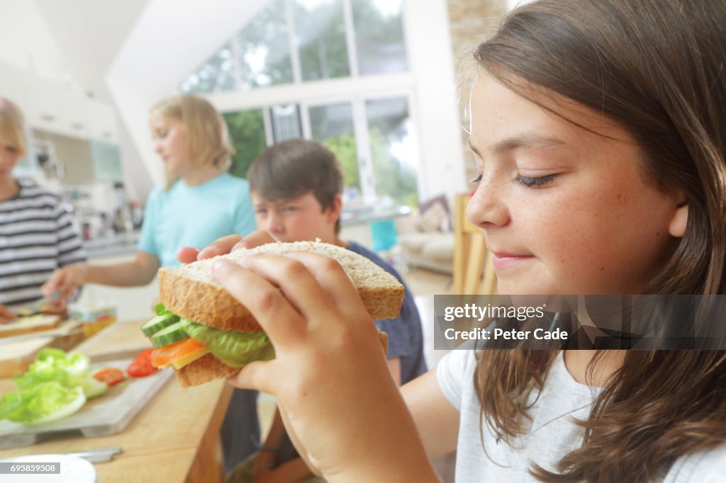 Children eating sandwiches they have made themselves