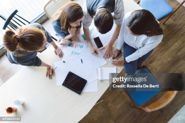 high angle shot of new entrepreneurs having a startup meeting - desk aerial view stock pictures, royalty-free photos & images