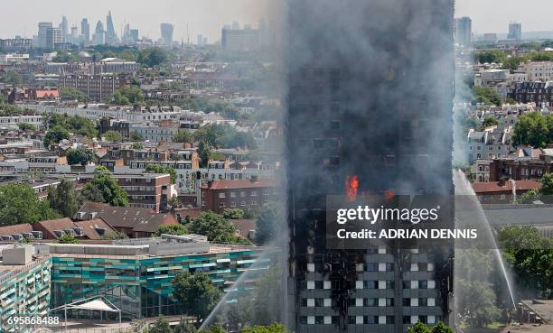 Smoke and flames billows from Grenfell Tower as firefighters attempt to control a blaze at a residential block of flats on June 14, 2017 in west...