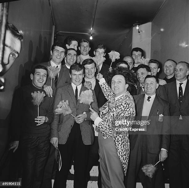 English comedian Ken Dodd with members of Liverpool F.C. And feather dusters, UK, 30th April 1965.