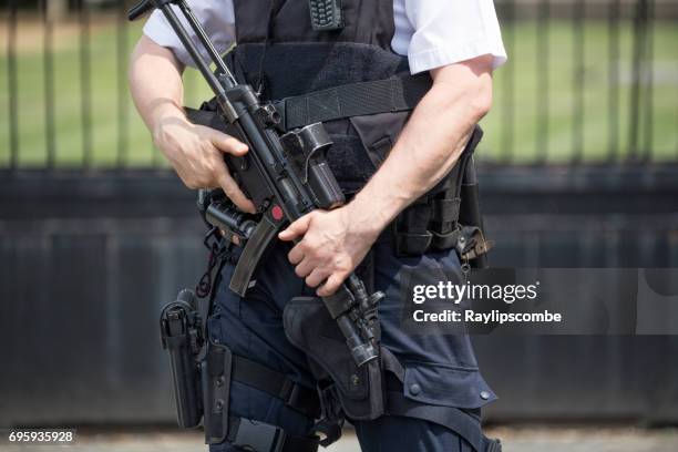 armed policeman standing guard outside the houses of parliament, westminster, london england - london police stock pictures, royalty-free photos & images