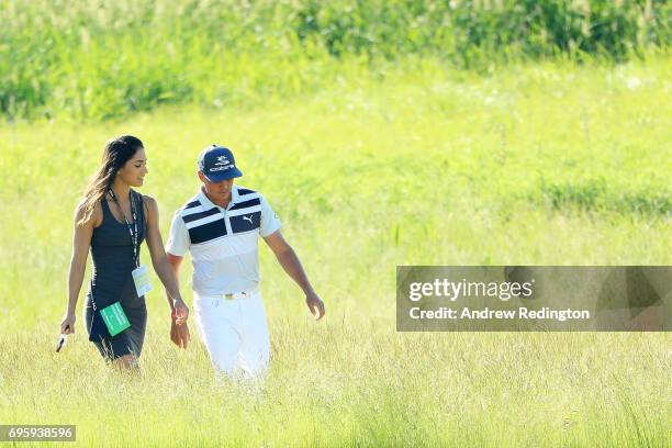 Rickie Fowler of the United States walks along the course with Allison Stokke during a practice round prior to the 2017 U.S. Open at Erin Hills on...