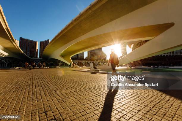 silhouette of a man walking under the bridge during sunset - valence espagne photos et images de collection