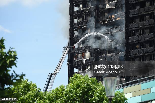 Smoke rises from the building after a huge fire engulfed the 24 storey residential Grenfell Tower block in Latimer Road, West London in the early...