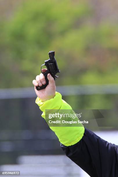 starters pistol in hand at track and field sports race - starter foto e immagini stock