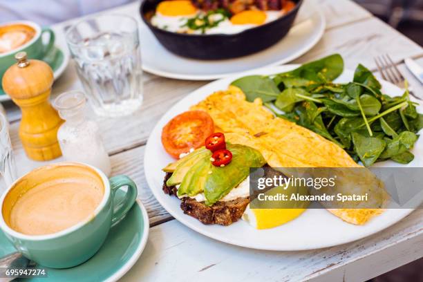 side view of omlete with avocado toast, spinach salad and coffee cup on the table - perfection salad stock pictures, royalty-free photos & images