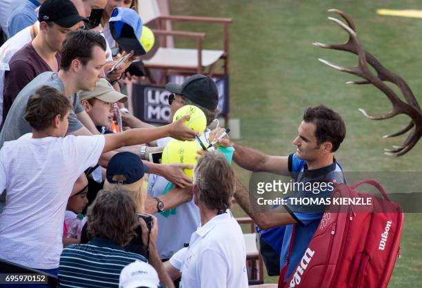 Switzerland's Roger Federer signs autographs after he lost against Germany's Tommy Haas in their round of sixteen match at the ATP Cup tennis...
