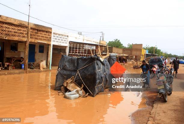 People are seen in a flooded way after torrential rains at the Saga neighborhood in Niamey, Niger on June 14, 2017.
