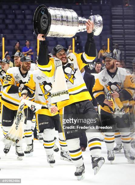 Sidney Crosby of the Pittsburgh Penguins and his teammates celebrate with the Stanley Cup trophy after defeating the Nashville Predators 2-0 in Game...